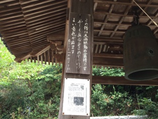写真:鐘と「恭しく真心をこめてつけばよい音色が出ます」と書かれた看板
